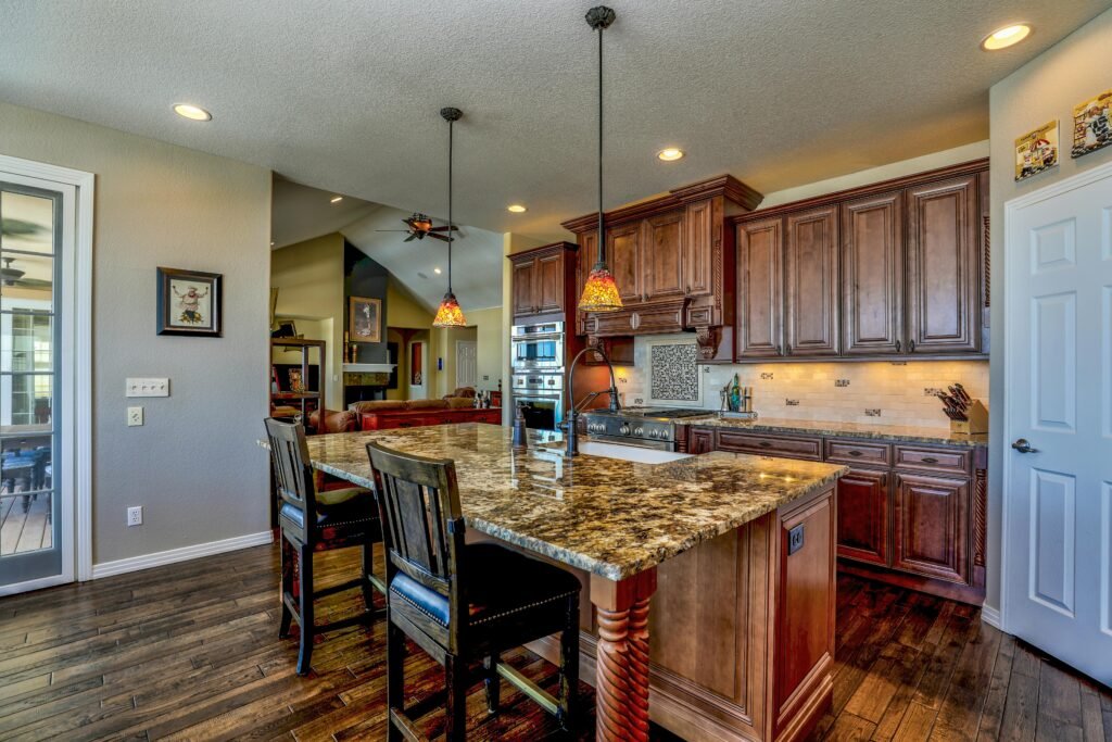 A stylish kitchen featuring a granite island, wooden cabinets, and modern appliances. Perfect blend of rustic and contemporary design.