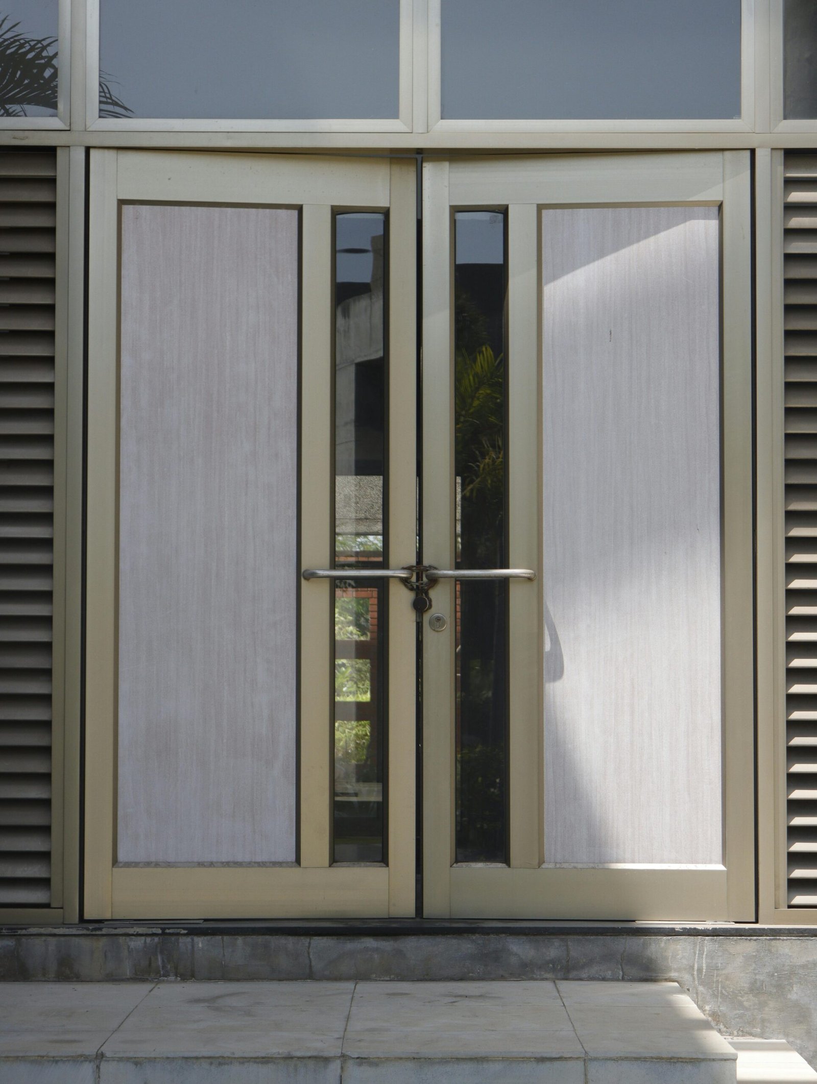 Contemporary glass and metal double doors leading into an urban building.